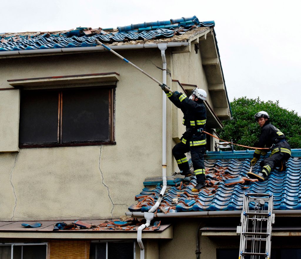 Oszaka, 2018. június 18.
Tűzoltók távolítanak el tetőcserepeket egy megrongálódott házról Oszakában 2018. június 18-án, miután 6,1-es fokozatú földrengés rázta meg Japán nyugati térségét. A természeti csapásban három ember életét vesztette, és több mint k