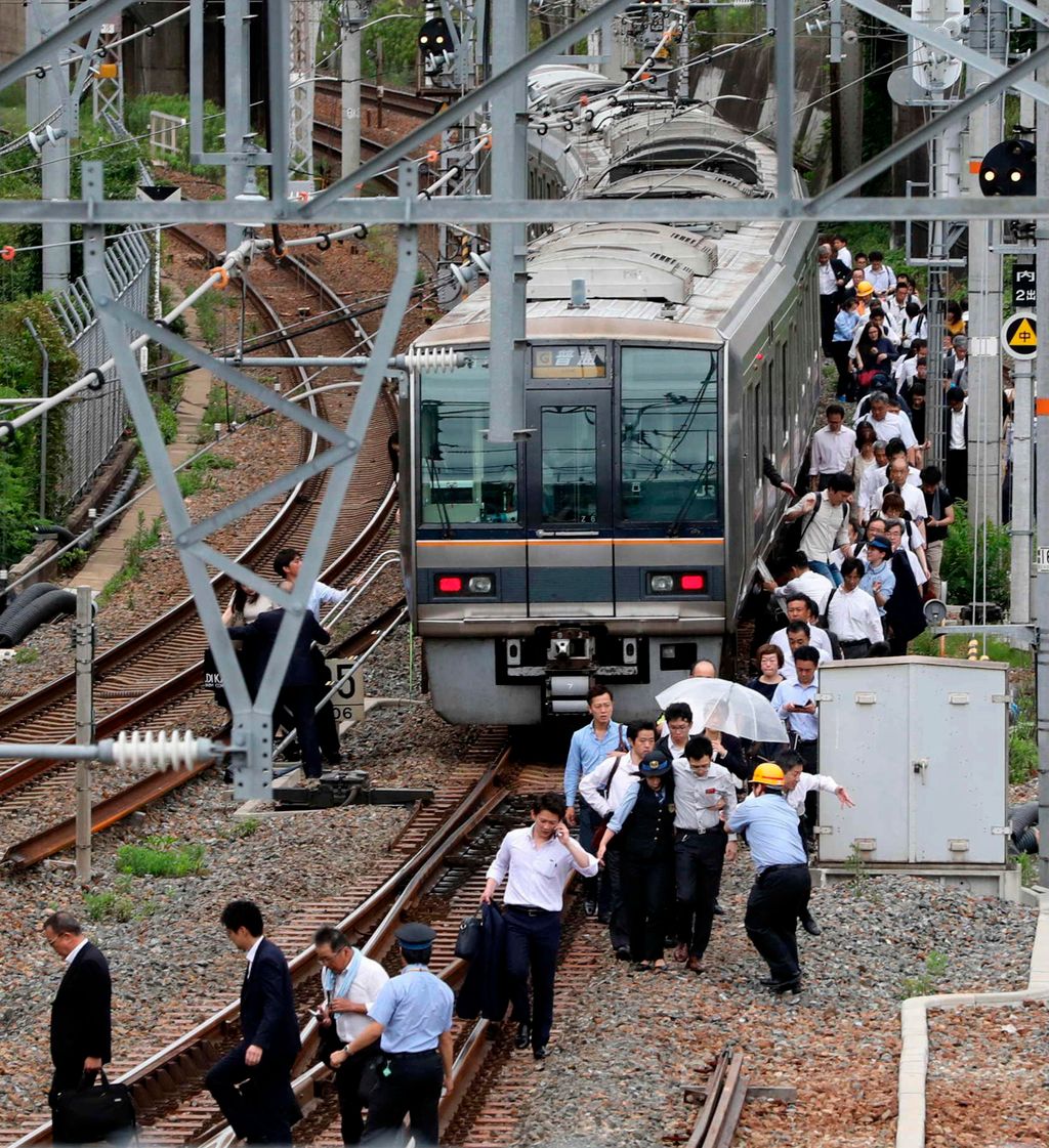 Oszaka, 2018. június 18.
Utasok gyalogolnak egy szerelvény mellett az oszakai vasúti pályaudvaron 2018. június 18-án, miután 6,1-es fokozatú földrengés rázta meg Japán nyugati térségét és felfüggesztették a  nagy sebességű Sinkanzen vasút és több tucat má