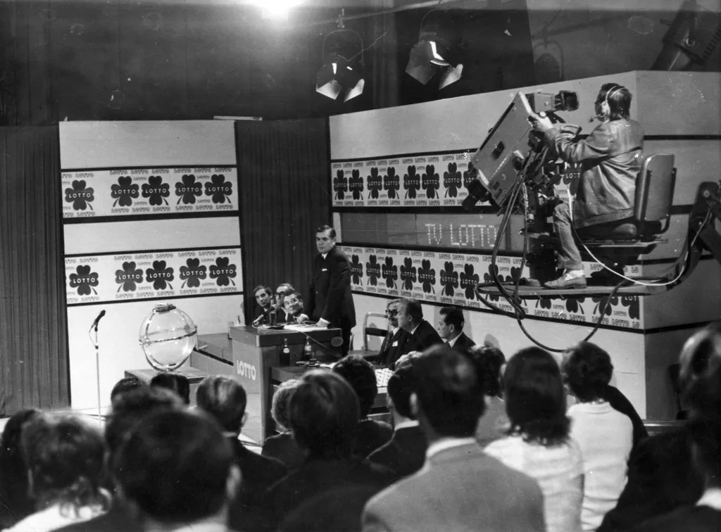 65 éve bevezették a lottót galér 
  Budapest V.
MTV stúdió, TV-Lottó sorsolás. Balról Somogyi Pál, Peterdi Pál, Kaposy Miklós, jobbról a harmadik Mikes György humoristák.
ÉV
1972 