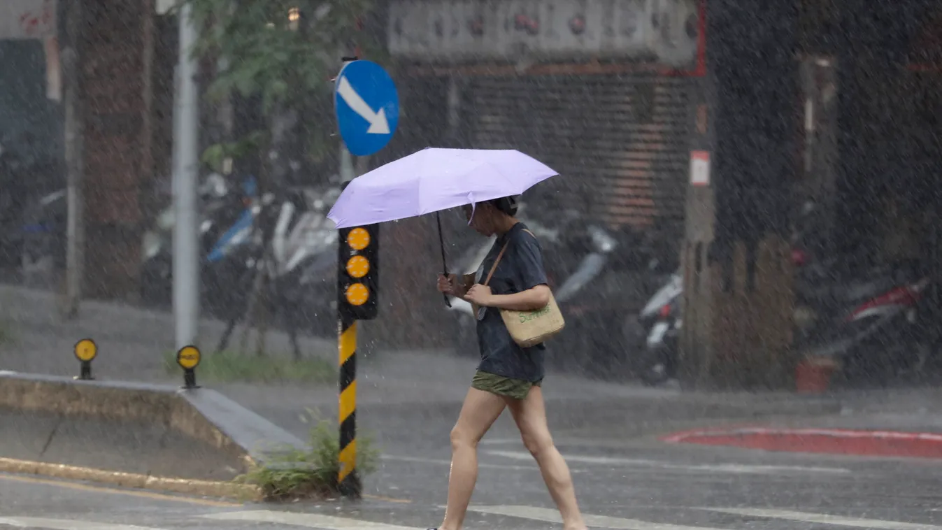 Tajpej, 2023. október 4.
Esernyővel közlekedő nő a szakadó esőben Tajpejben 2023. október 4-én. Heves esőkkel és erős szelekkel közelít a Koinu tájfun Tajvan felé, ezért a hatóságok munkaszüneteket és iskolák bezárását rendelték el, valamint több mint 100