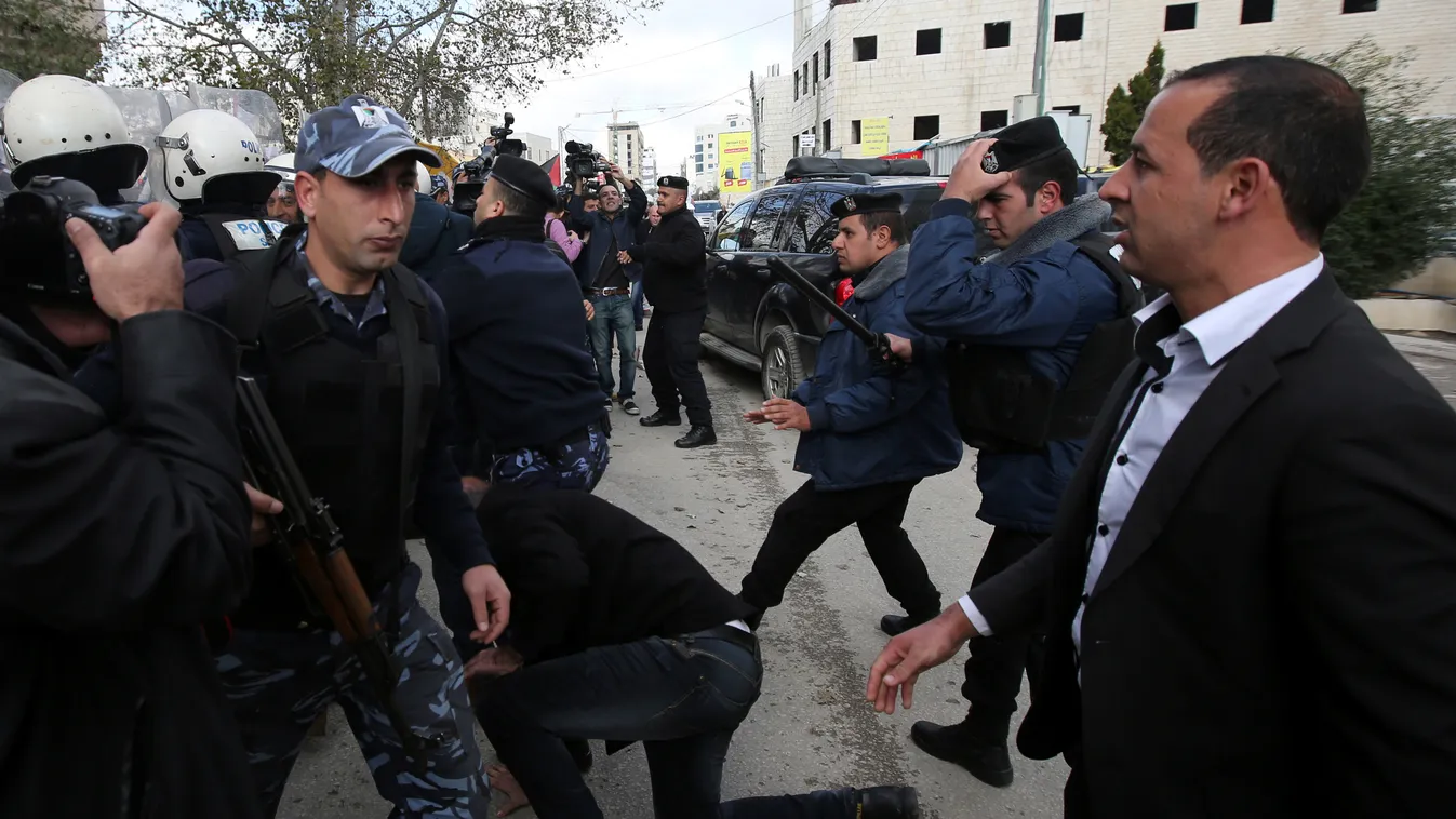 Policemen disperse protesters outside the Foreign Affairs ministry after angry Palestinian youths hurled eggs at the motorcade of Canadian Foreign Minister John Baird after his meeting with his Palestinian counterpart on January 18, 2015 in the West Bank 