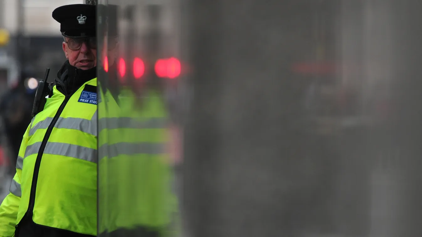 A police support officer walks past a sign outside New Scotland Yard, the headquarters of the Metropolitan Police, in central London on January 11, 2013,  following the report by the Metropolitan Police and NSPCC (National Society for the Prevention of Cr