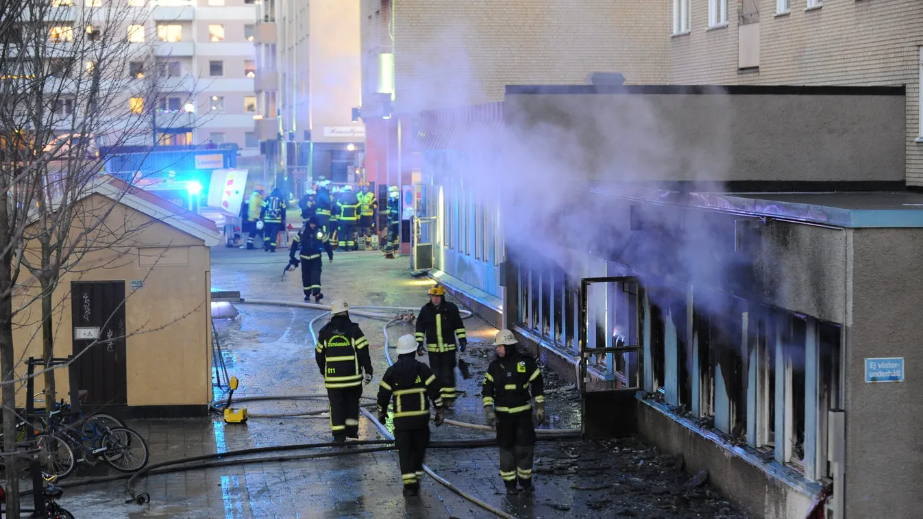 Smoke rises from the interior of a destroyed cellar mosque as firefighters walk in front of the building after an arson attack on December 25, 2014 in Eskilstuna, central Sweden. An arsonist set fire to the mosque in central Sweden on Thursday injuring fi