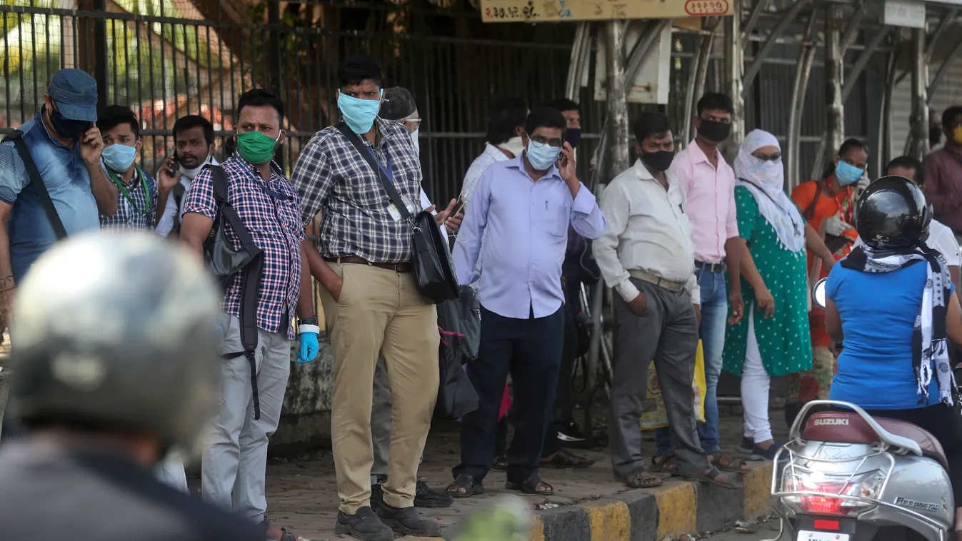 Védőmaszkot viselő emberek várják a buszt a nyugat-indiai Mumbaiban 2020 június 8-án. India legtöbb államában elkezdték enyhíteni a koronavírus-járvány miatt két hónappal ezelőttt bevezetett korlátozásokat. 