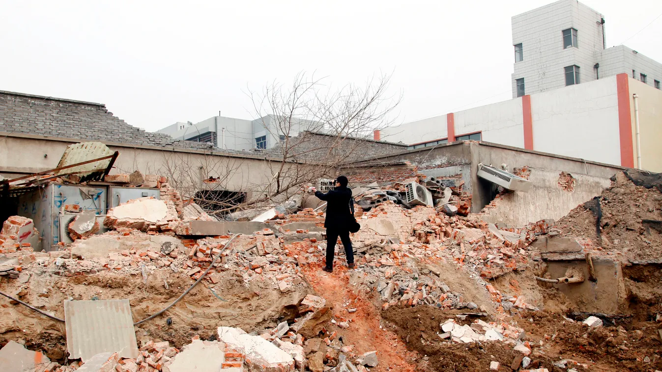 China Chinese Henan Zhengzhou hospital radiology radiation demolition SQUARE FORMAT A man takes pictures on debris after part of the radiology department building was demolished at the Fourth Affiliated Hospital of Zhengzhou University in Zhengzhou city, 