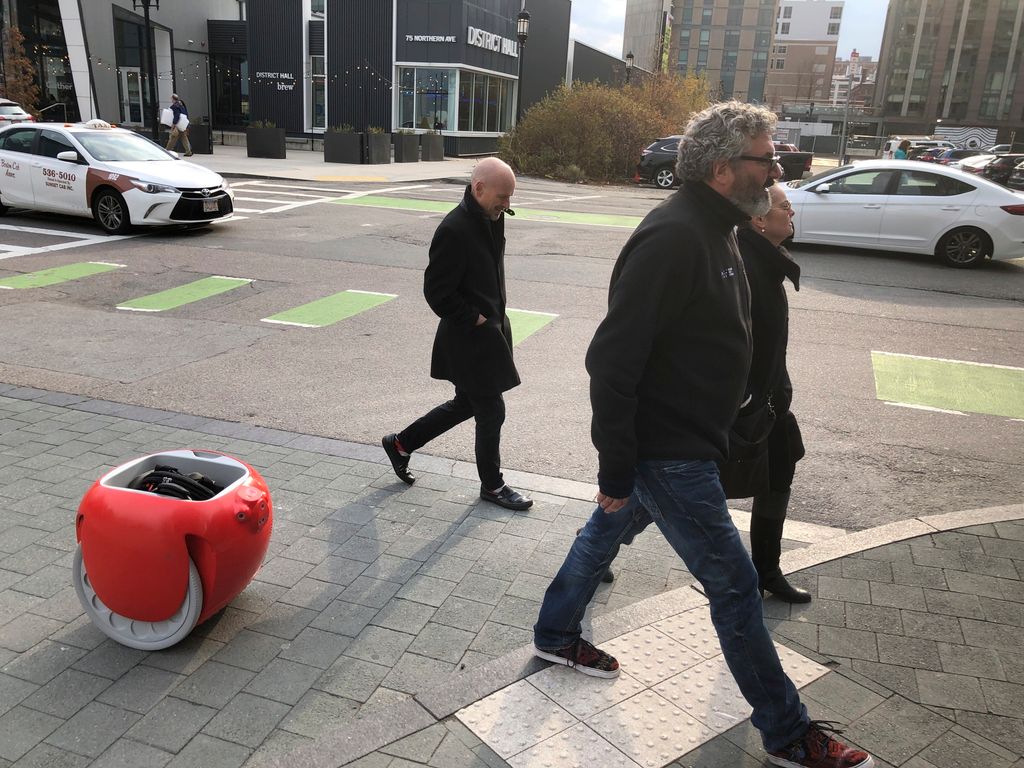 Boston, 2019. november 25.
A Gita teherszállító robot engedelmesen követi Greg Lynnt, a Piaggio Fast Forward vállalat vezérigazgatóját (j2) Bostonban 2019. november 11-én. A vásárláskor belépakolt cikkekel megrakott kétkerekű gép beépített érzékelők és kamerák segítségével képes követni tulajdonosát.
MTI/AP/Matt O'Brien 