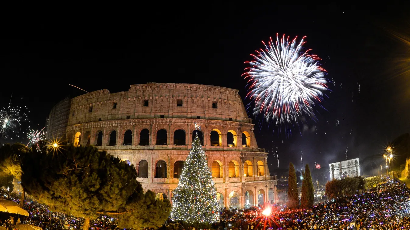People cheer in front of Rome's ancient Colosseum as fireworks explode to celebrate the new year on January 1, 2015.  AFP PHOTO / ANDREAS SOLARO 