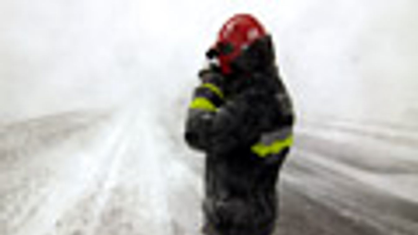havazás, hóhelyzet, időjárás, Tűzoltó dolgozik a hófúvásban a Tapolcára vezető behavazott úton történt baleset helyszínén, Tótvázsony határában 2013. március 14-én