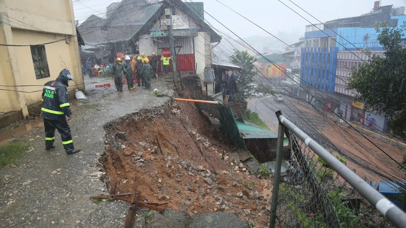 Baguio, 2023. július 26.
Rendőr néz egy beomlott úttestet a Fülöp-szigeteki Baguio városban 2023. július 26-án, a Doksuri tájfun elvonulása után. A hatalmas esővel érkező forgószél lakóházak tetőszerkezetét rongálta meg, az alacsonyan fekvő területek víz 