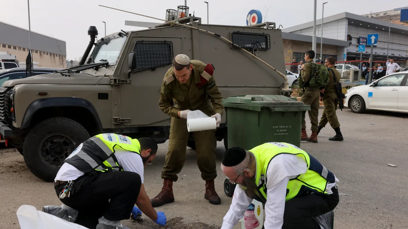 Vérfoltot takarítanak fel a Zaka izraeli önkéntes mentőszervezet tagjai egy katonával a támadás egyik helyszínén, a ciszjordániai zsidó telep, Ariel ipari övezeténél. 