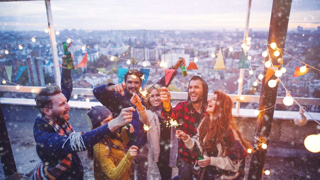 Group of friends at rooftop party New Year's Day Real People Social Gathering Beer Bottle Young Women Young Men Group Of People Comfortable Weekend Activities Adults Only City Life Sparkler Christmas Lights Lantern Scarf Music 25-29 Years Young Adult Smil
