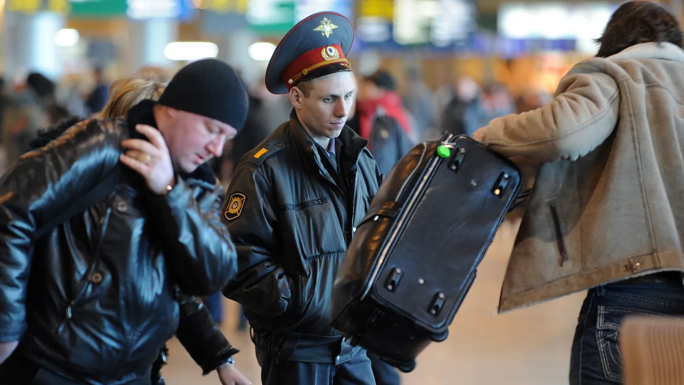 Orosz rendőr vizsgál az utasok poggyászait a Domogyedovo repülőtéren, Moszkva, 2011. január. 