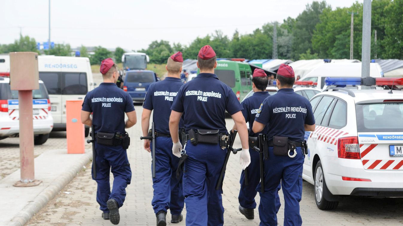 Röszke, 2015. június 25.
A Készenléti Rendőrség munkatársai a röszkei hangárnál 2015. június 25-én. Az épületben és a szomszédságában felállított sátrakban őrzik az első 24 órában azokat a határsértőket, akiket Csongrád megyében fogtak el. A rendőrség bev