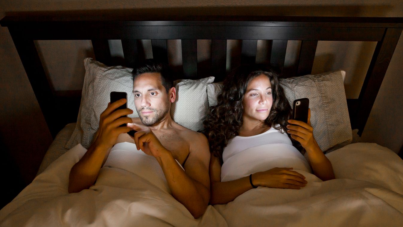 Phones in Bed Couple Smart Phone Wireless Technology Bedtime Busy Dishonesty E-Mail Young Adult Looking Suspicion Problems Bonding Togetherness Dark Technology Social Issues Lifestyles Pensive Heterosexual Couple People Night Bedroom Internet Laptop Mobil