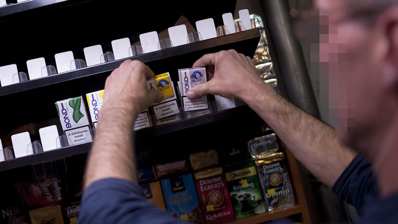 becsődölő tarfikok, nemzeti dohánybolt, Az utolsó doboz cigarettákat pakolja el az eladó egy II. kerületi üzletben 2013. július 15-én