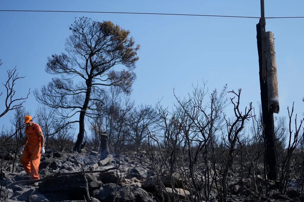 tűzoltó tomboló erdőtűz Görögország  villanyoszlopokat ellenőrzi egy áramszolgáltató dolgozója az Athéntól nyugatra fekvő Agia Sotirában 2023. július 19-én. Az Európai Unió egyik polgári védelmi mechanizmusának keretében Francia 
