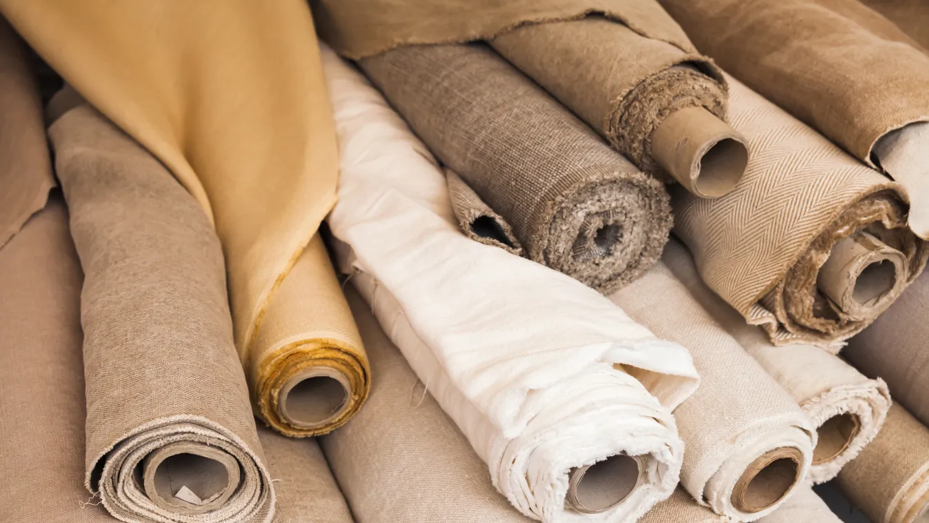 Rolls of linen cloth lie on the market counter 