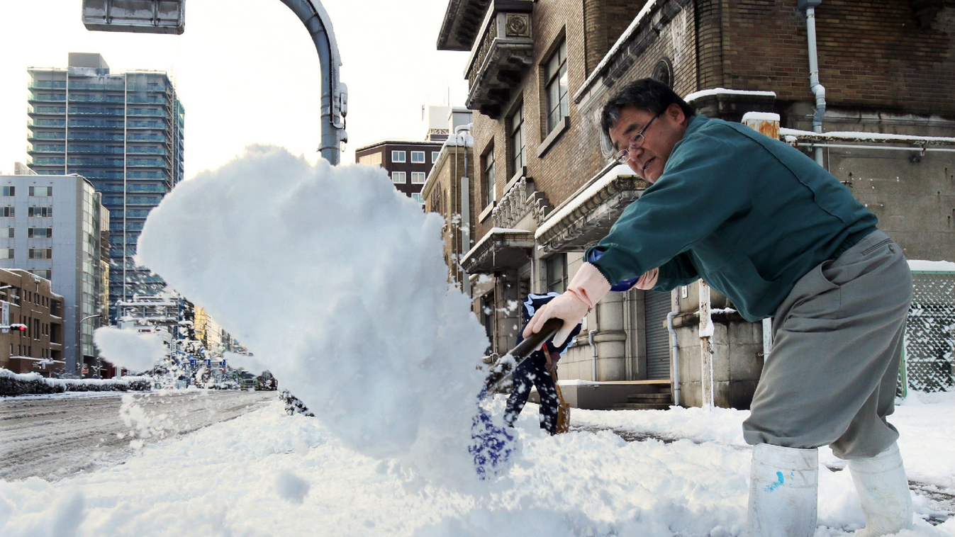 HORIZONTAL STREET WINTER STREET-CLEANING SNOW SNOWSTORM A man removes snow from a sidewalk in Nagoya in Aichi prefecture, central Japan on December 18, 2014 as heavy snow hit wide areas of Japan. Heavy snow keeps mounting in northern Japan, accumulating t