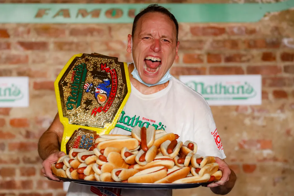 New York, 2020. július 4.
Joey Chestnut ünnepel a bajnoki övével a július 4-i amerikai nemzeti ünnep alkalmából megrendezett Famous Nathan's hotdogevőverseny után New York Brooklyn negyedében, 2020. július 4-én. Chestnut 75 hotdog felfalásával tizenharmad