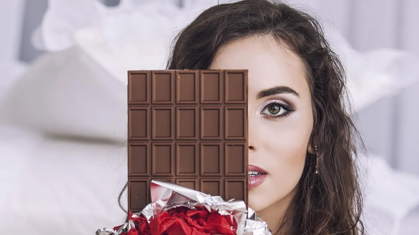 Beautiful woman model with tiles of dark chocolate in hands Beautiful Ceremonial Make-up Portrait Girls Women Stage Make-up Gourmet Fine Art Portrait Softness Cute Dessert Young Adult Smiling Looking Eating Wrapping Paper Holding Refreshment Beauty Caucas