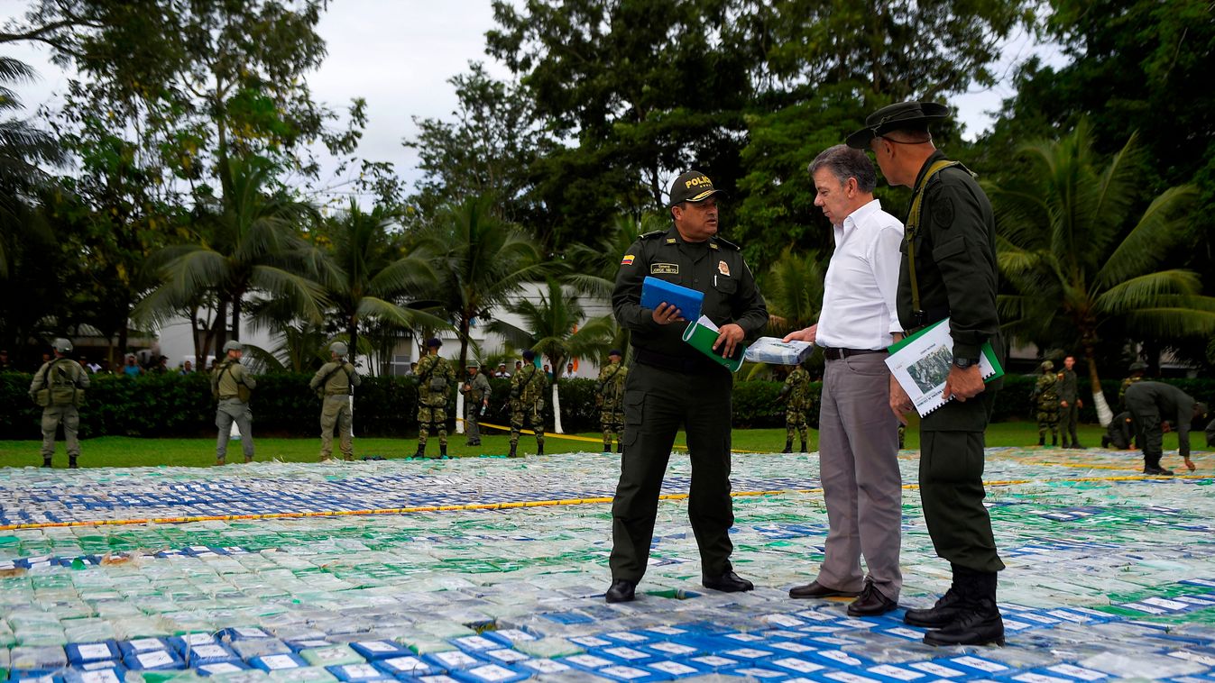 politics Horizontal This handout picture released by Colombia's Presidency shows President Juan Manuel Santos listens to a member of the anti-narcotics police as he walks over 12 ton of cocaine on November 8, 2017 in Apartado, Antioquia, Colombia.
Santos 