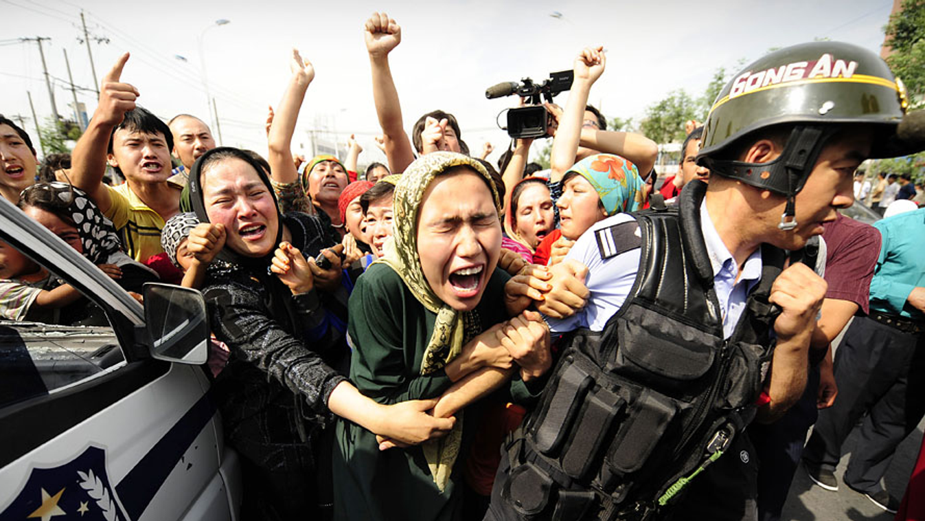 Xinjang Uyghur autonom terület, ujgur asszonyok rángatnak egy kínai rohamrendőrt egy tüntetésen 2009-ben