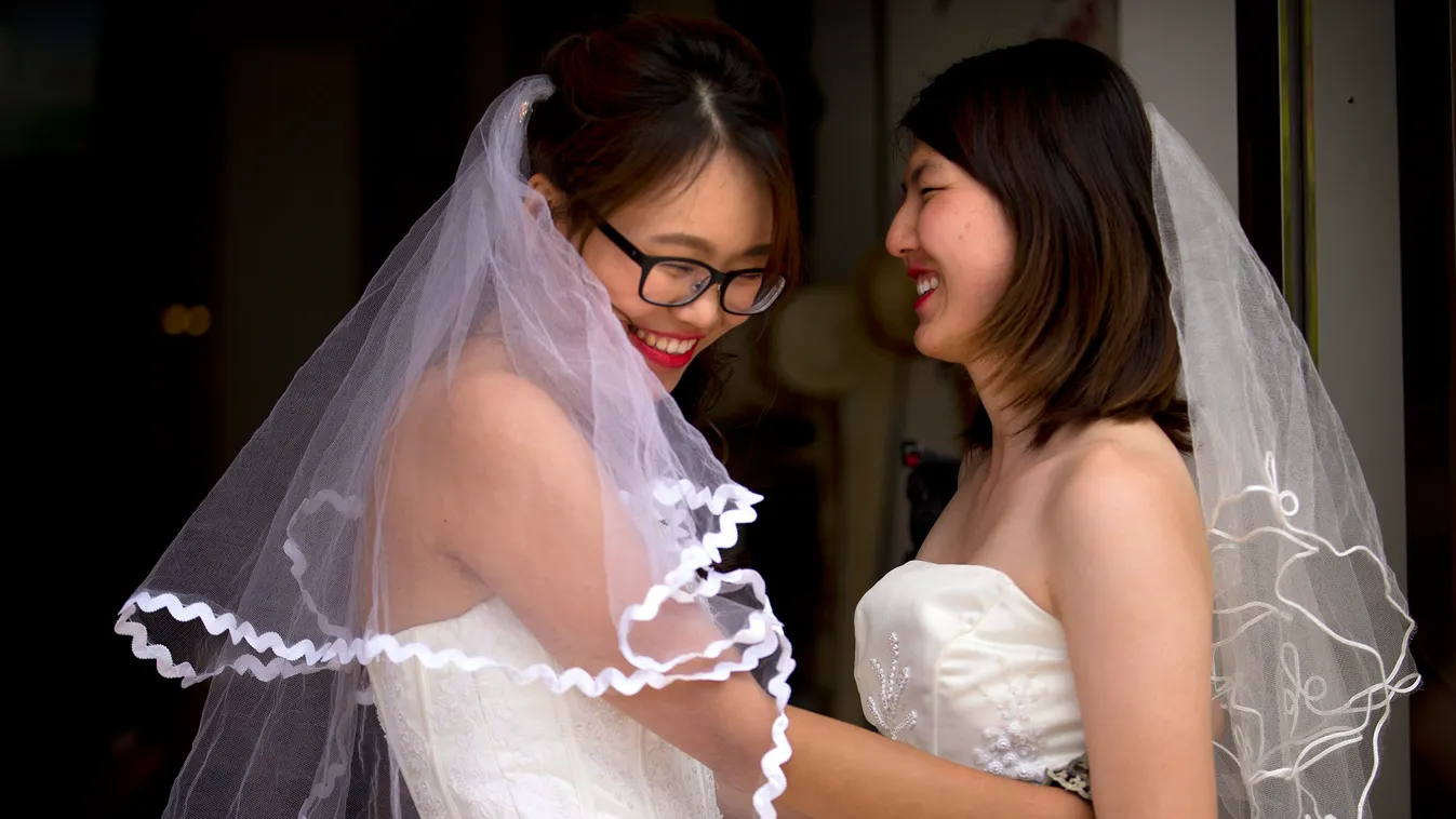 Peking, 2015. július 2.
Teresa Hszü (b) és Li Ting-ting leszbikus nőjogi aktivista egy pekingi szépségszalon előtt, ahol a nem hivatalos esküvőjükre készülődnek 2015. július 2-án.  Mennyegzőjével a kínai leszbikus pár az együttélését jelenti be és az azon
