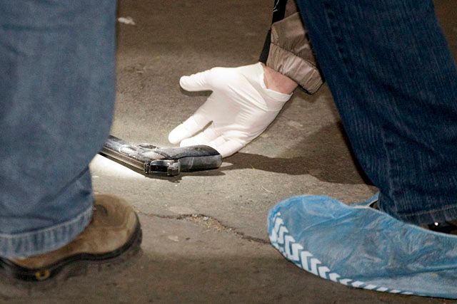 Rendőrségi szakértők vizsgálják a Miklós utca 9-15. szám alatti tízemeletes panelház előtt talált pisztolyt