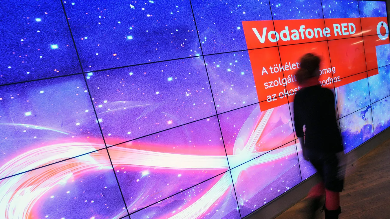 A Vodafon Red szolgáltatását reklámozó szöveg mellett megy el egy résztvevő a Vodafone Magyarország Zrt. budapesti sajtótájékoztatóján 2012. október 1-jén