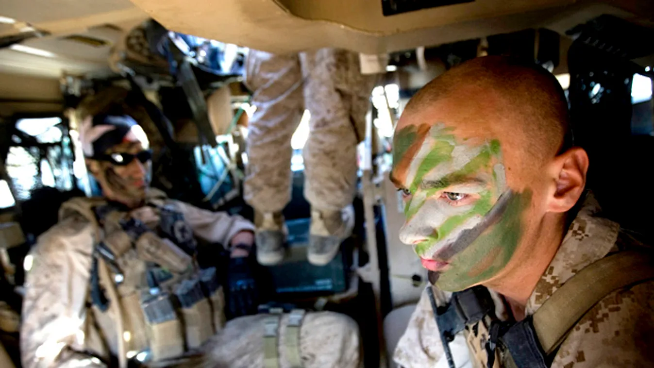 Amerikai katonák álcafestéssel az arcukon ülnek egy harckocsiban Irakban, camouflage