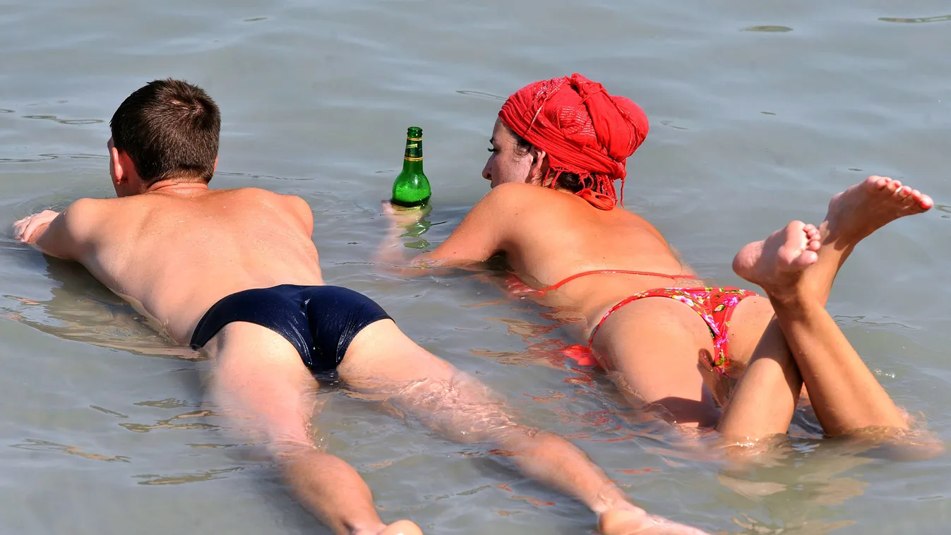 kánikula, hőségriadó, Hűsölők hasalnak a bokáig érő Balaton vizében a siófoki strandon
