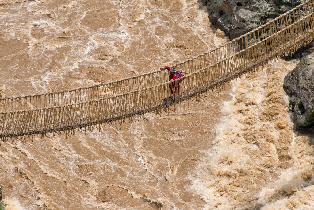 Quechua,Woman,Crossing,Queshuachaca,(q'eswachaka),Rope,Bridge,,One,Of,The travel destination,woman,quehue,rope,handwoven,peru,incan,horizo Quechua woman crossing Queshuachaca (Q'eswachaka) rope bridge, one of the last standing Incan handwoven bridges, Que