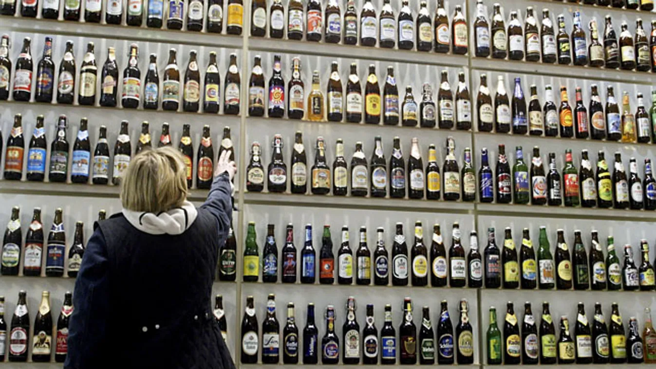 sörivás, ízesített sör, egy nő válogat a palackozott sörök között egy német sörvásáron 