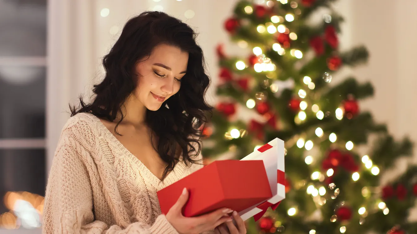 Curious,Happy,Romantic,Woman,Standing,Against,Christmas,Tree,Background.,Cheerful gift,cozy,caucasian,happy,smile,red,beautiful,holidays,casual,mo 