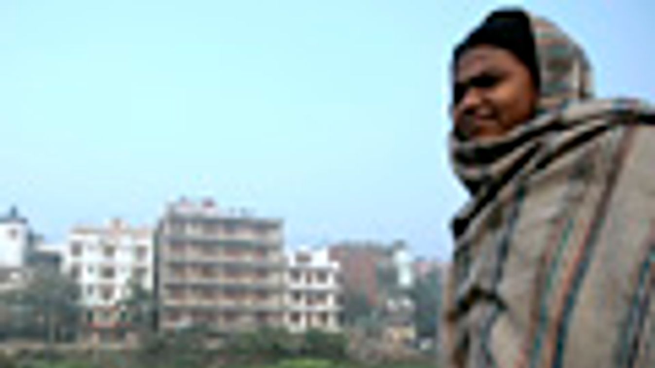 túlnépesedés, túlnépesedtt városok, egy asszony áll füldje mellett Delhi egyik elővárosában