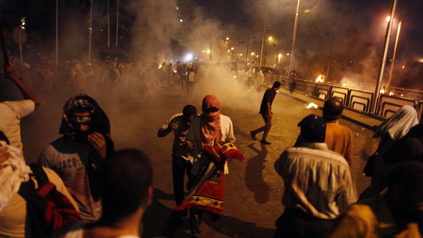 Mohamed Murszi leváltott elnök támogatói menekülnek a könnygázfelhőkből miután a tömegbe lőttek a katonák Kairóban, 42 iszlamistát öltek meg a hétvégén