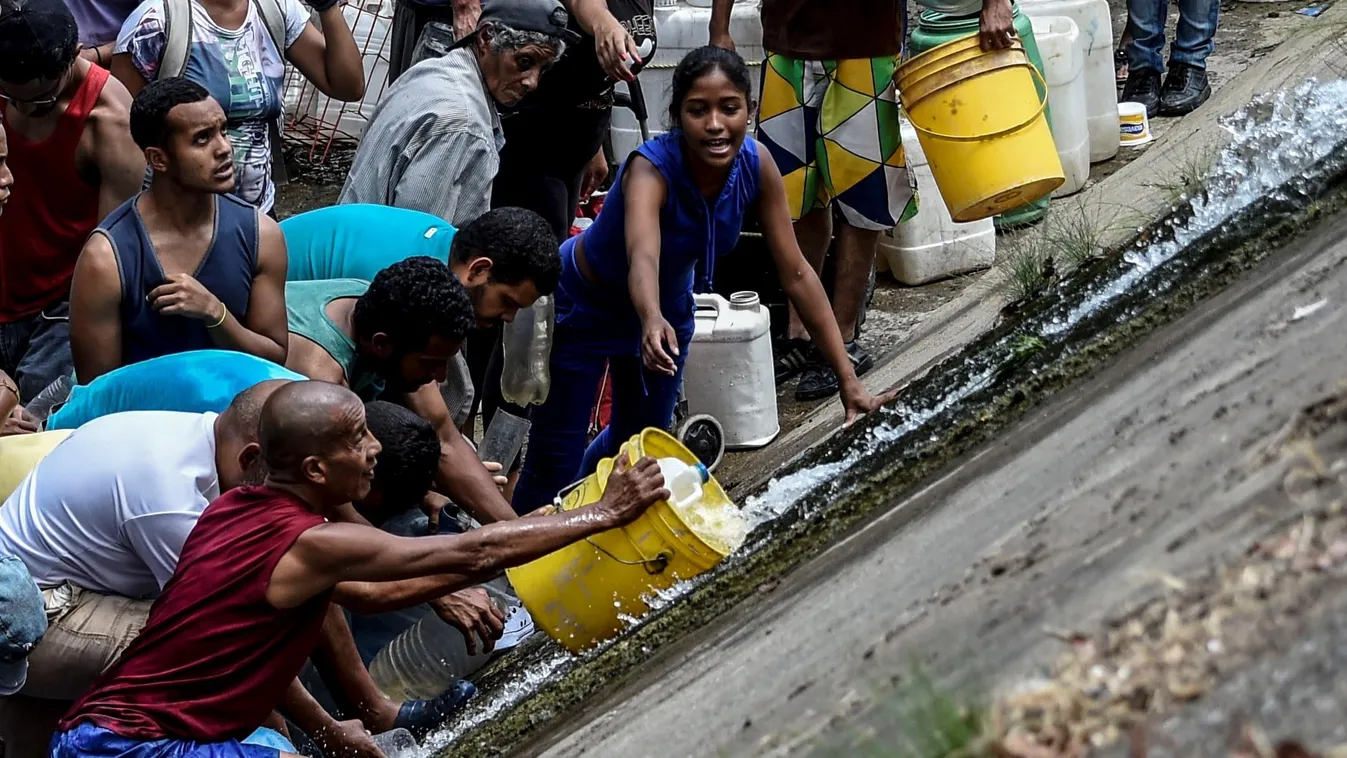 TOPSHOTS Horizontal POWER CUT SHORTAGE DRINKING WATER People collect water from a sewage canal at the river Guaire in Caracas on March 11, 2019, as a massive power outage continues affecting some areas of the country. - Venezuela's opposition leader Juan 