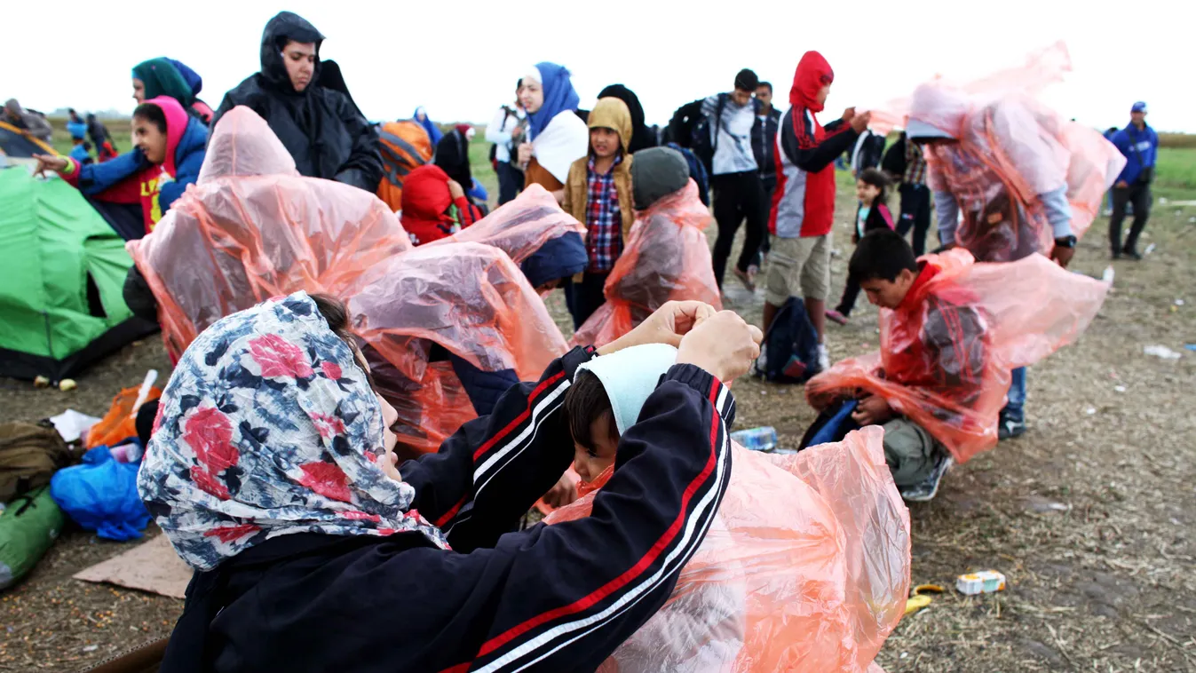 Röszke mellett a Szabadka-Szeged vasútvonal töltésénél gyűjtik össze a menekülteket, a buszra várókat elkapta a zápor. Afgán hazara nemzetiségű meneköltek műanyag zsákkal védekeznek
Fotó:Dudás Szabolcs 