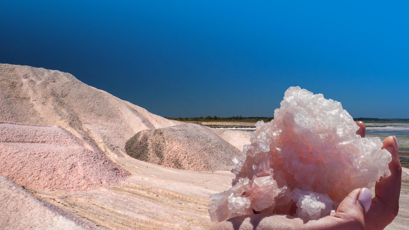 Pink,Salt,Crystals,In,A,Hand,And,Landscape,With,A 