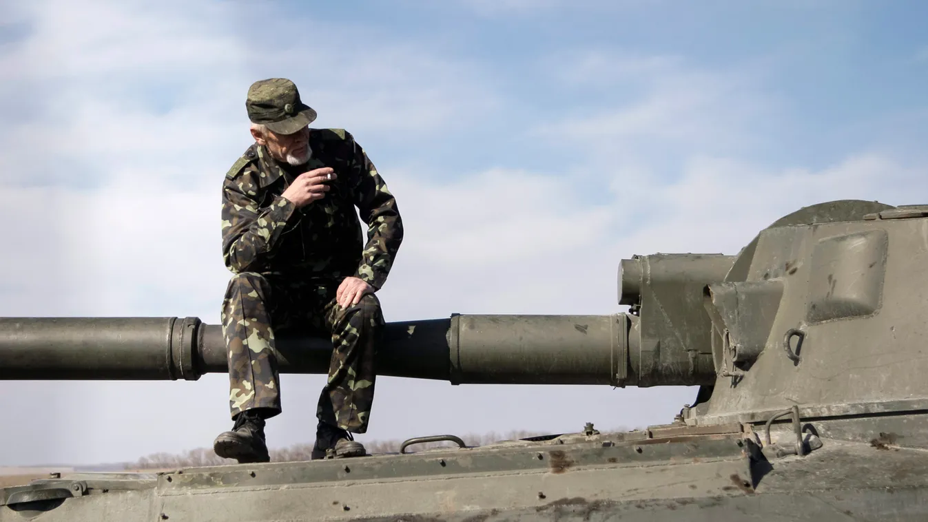 Az oroszbarát szakadárok egyike dohányzik egy páncélozott harcjármű tetején a kelet-ukrajnai Donyeck közelében tartott gyakorlatozáson. 