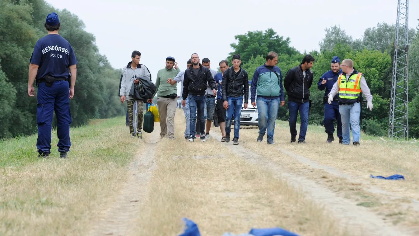 menekültek illegális bevándorló menekült rendőr SZEMÉLY idegenrendészet Szeged, 2015. június 24.
Rendőrök őrzik a határsértőket, akiket a Tisza árterében, Szeged közelében fogtak el 2015. június 24-én. A rendőrség idegenrendészeti akció keretében átfésül 