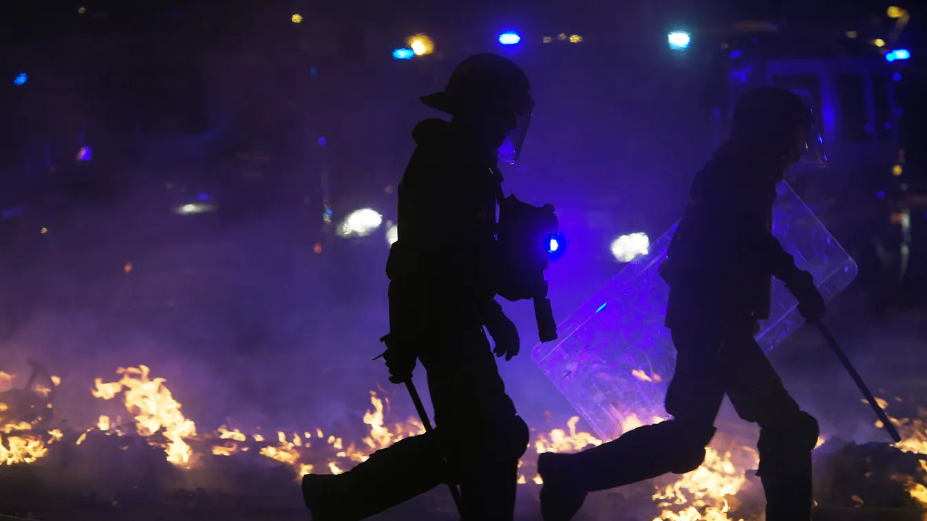 politics demonstration Horizontal Catalan anti-riot police officers walk past a burning barricade during a demonstration called by the local Republic Defence Committees (CDR) in Barcelona on October 16, 2019, after police arrested 51 people across Catalon