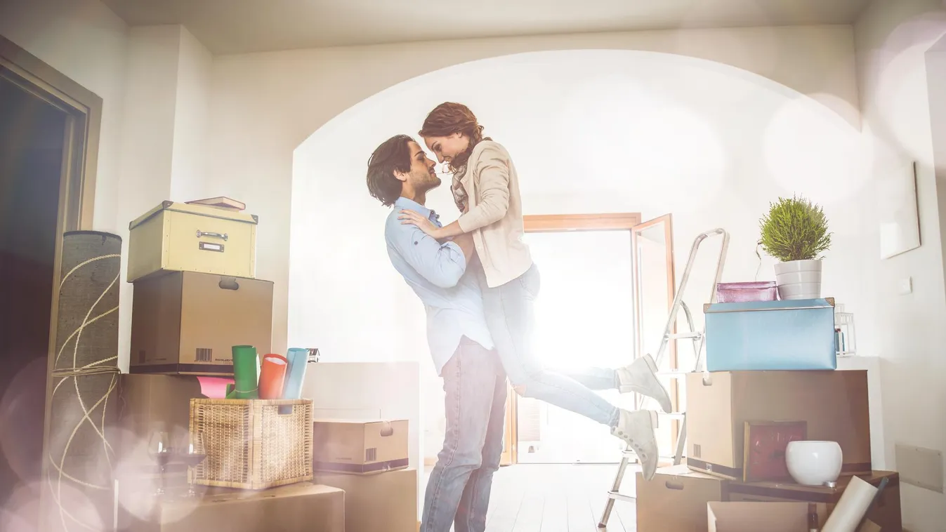 Young couple moving in into new apartment 30-39 Years Domestic Life Home Interior Home Ownership House Rental Moving House New Life Unpacking adult apartment box bright candlestick cardboard carrying casual clothing city container couple day family female