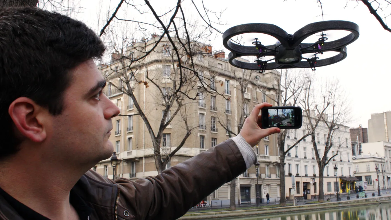 HORIZONTAL (FILES) Picture taken on January 13, 2010 in Paris, shows a man maneuvering an AR.drone from French company Parrot -- a small remote-controlled helicopter using the accelerometer in an Apple iPhone -- . Investigators in Paris have been left puz