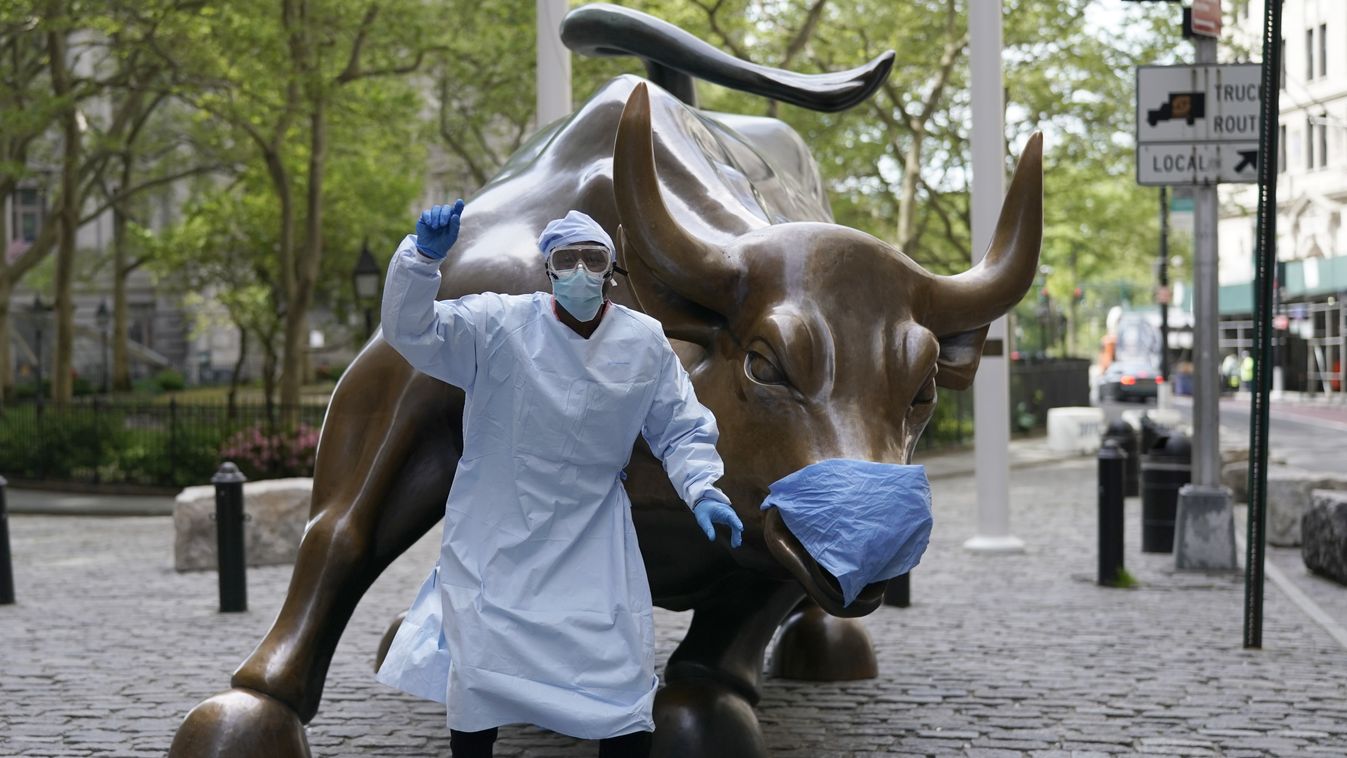 Horizontal Julius Shakari, from California in full PPE gear, takes photos with his friend in front of the Charging Bull, sometimes referred to as the Wall Street Bull, a bronze sculpture in the Financial District of Manhattan New York May 19, 2020. (Photo