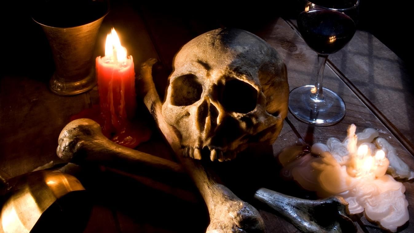 chalice goblet skull ceremonial bones moonlight table wood creepy death dead ritual skeleton religion evil halloween scary real skull and bones over a table, with candles and chalice. 