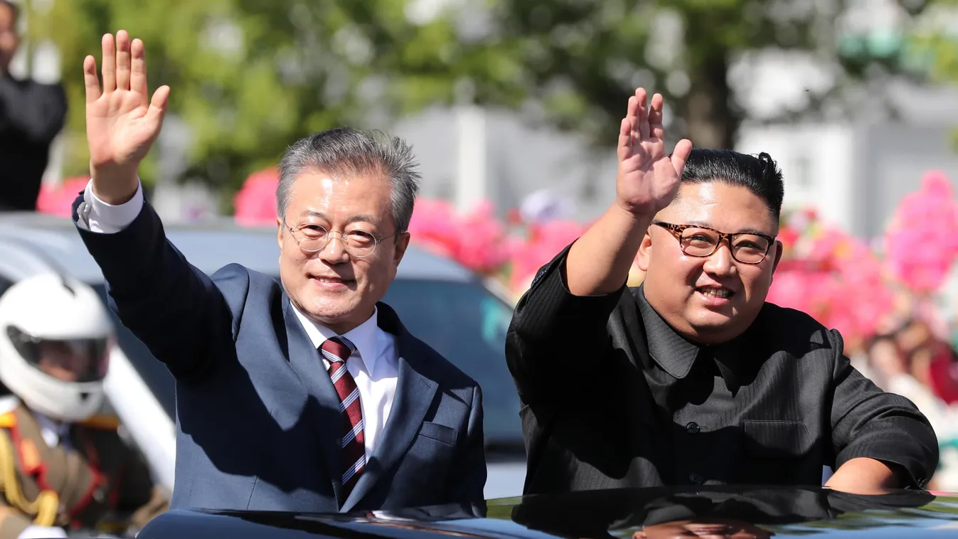 TOPSHOTS Horizontal North Korean leader Kim Jong Un (R) and South Korean President Moon Jae-in (L) wave to Pyongyang citizens from an open-topped vehicle as they drive through Pyongyang on September 18, 2018.
South Korea's president and the North's leader