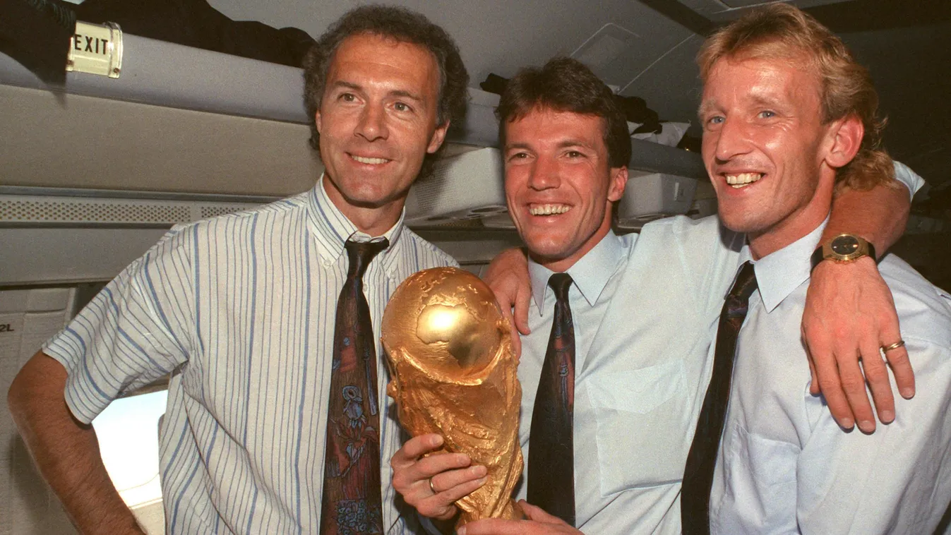 Soccer World Cup 1990: Germany wins world cup .Fußball .Personen .Sport .WM .Weltmeisterschaft 1990 Cup Germany People Pokal SPO SPORT Trophäe WM-Pokal airplane CABIN lachen LAUGHING presenting SMILING soccer TROPHY umarmen WORLD CHAMPION WORLD CUP HORIZO
