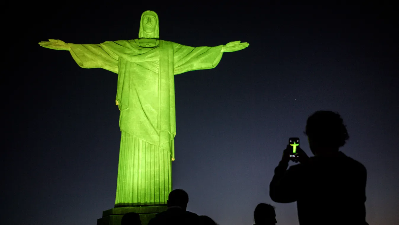 Horizontal OFFBEAT OLYMPIC AMBIANCE CHRIST THE REDEEMER STATUE NIGHT GREEN COLOUR CAST TOURIST SMARTPHONE BACKLIT PHOTOGRAPHING ILLUSTRATION 