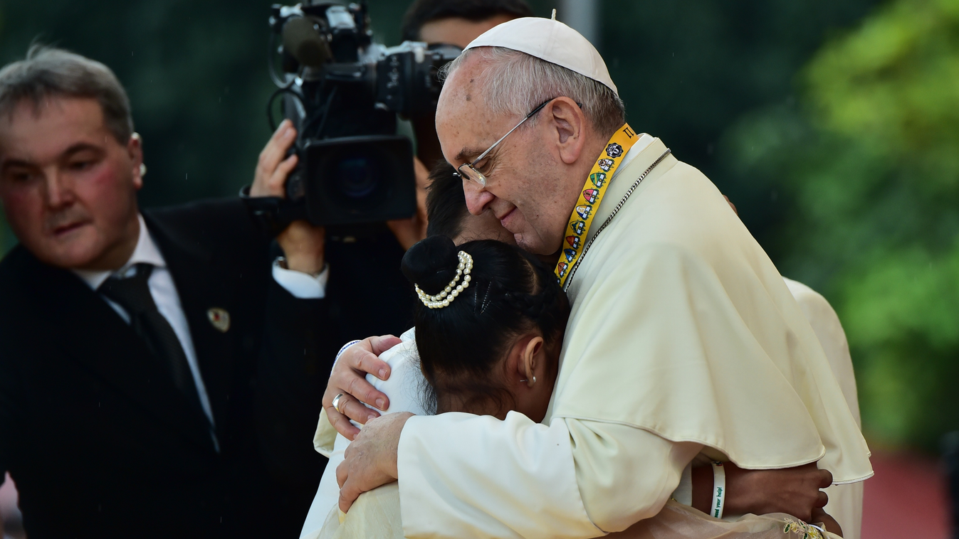 CORRECTION-ADDING NAME
Pope Francis (R) embraces two children, including 12-year-old Glyzelle Palomar (2nd R), during his visit to the University of Santo Tomas in Manila on January 18, 2015.  Pope Francis will celebrate mass with millions in the Philippi